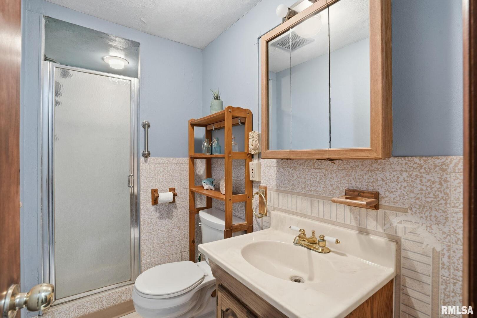 516 4th Street Buffalo, IA 52728 - Photo 18 of 26 a bathroom with a sink toilet and shower