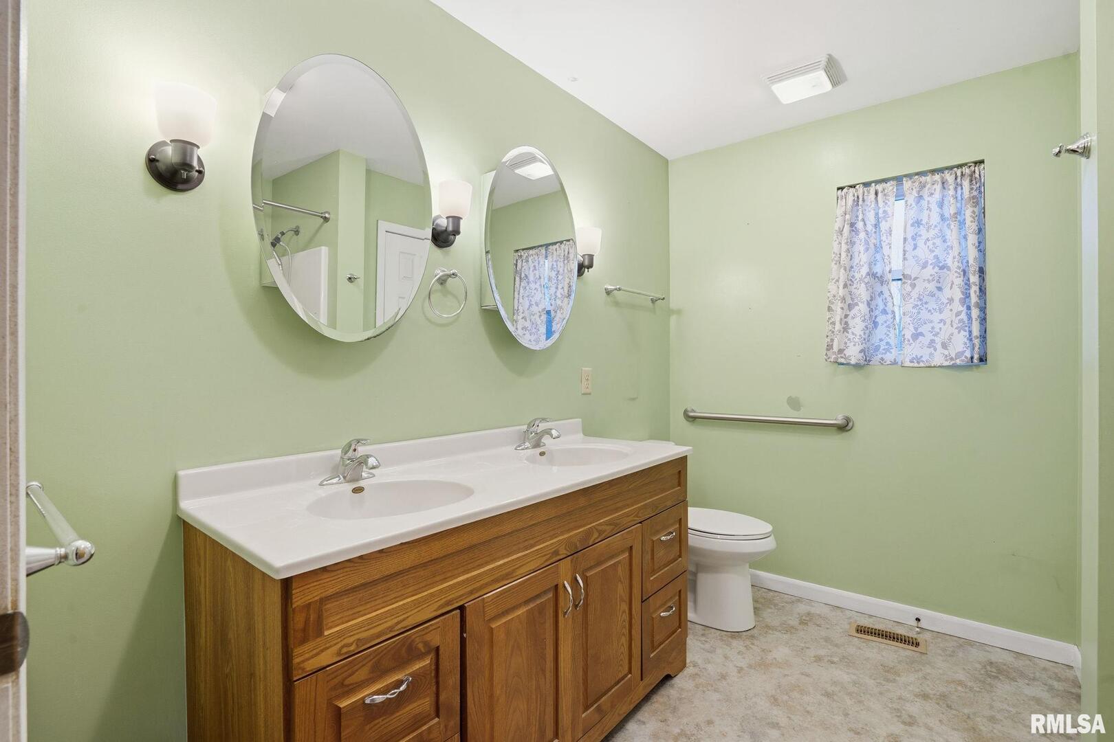 516 4th Street Buffalo, IA 52728 - Photo 9 of 26 a bathroom with a toilet sink and mirror