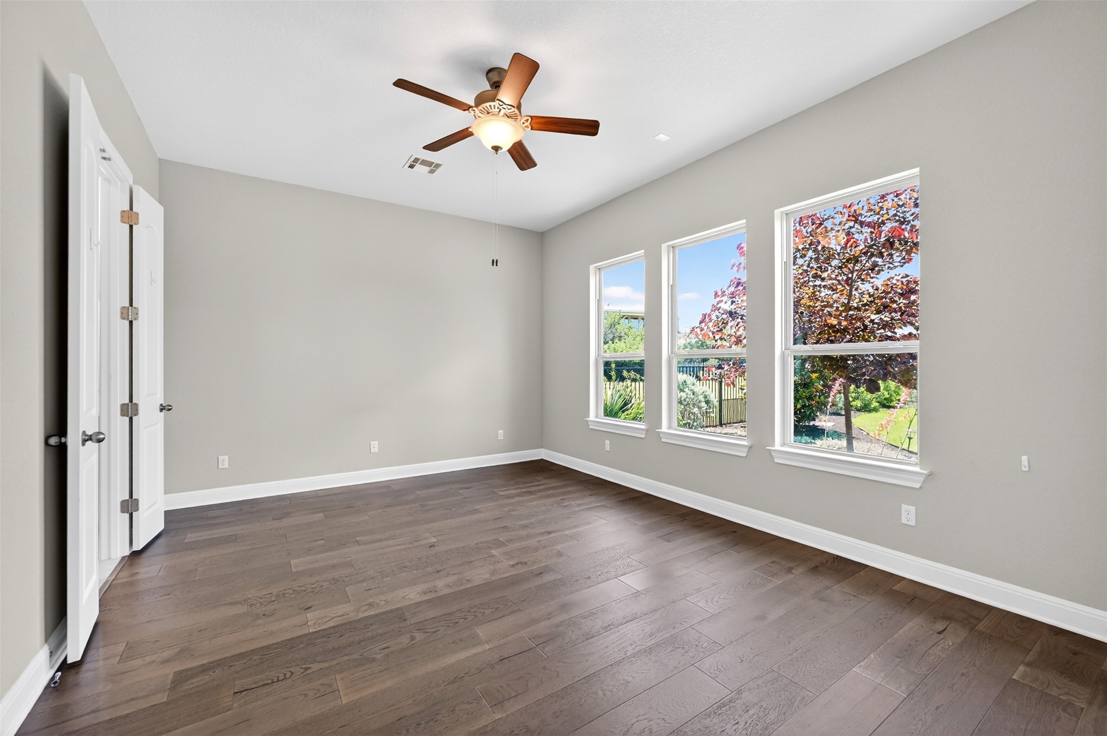 1201 Positano Pass Leander, TX 78641 - Photo 23 of 40 Spacious room featuring wood-finish flooring, light gray walls, and white baseboards