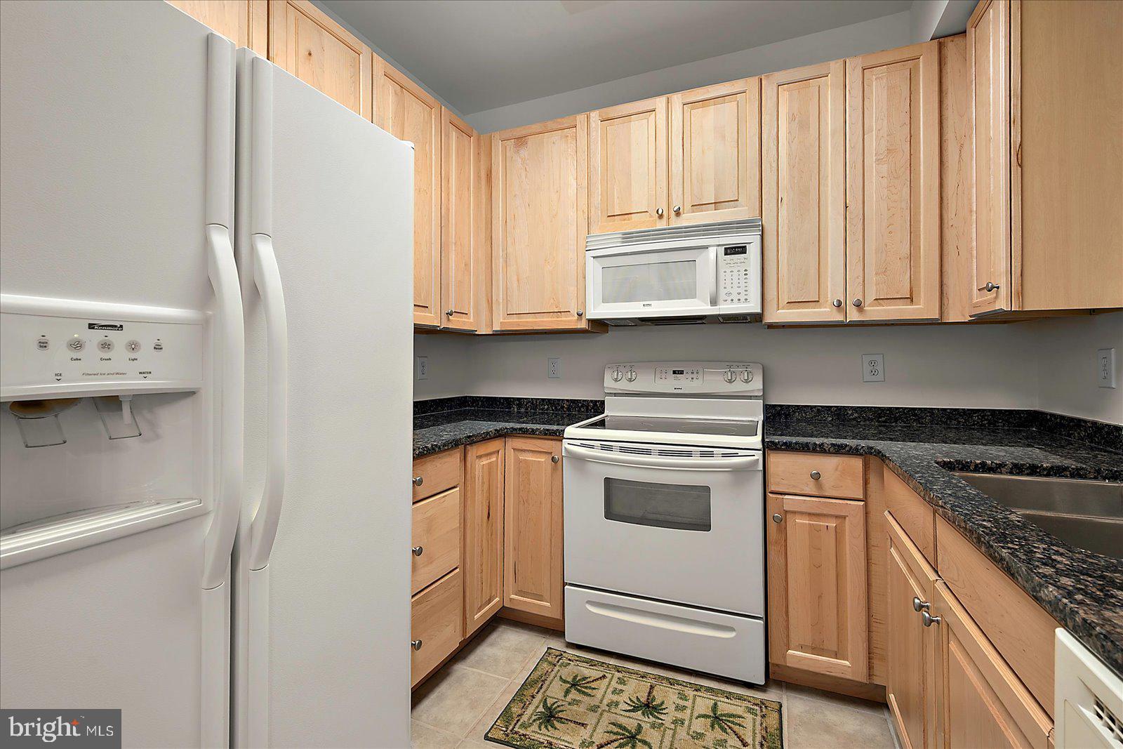 30611 Cedar Neck Road, Unit 2107 Ocean View, DE 19970 - Photo 14 of 44 a kitchen with stainless steel appliances granite countertop white cabinets sink and a granite counter top