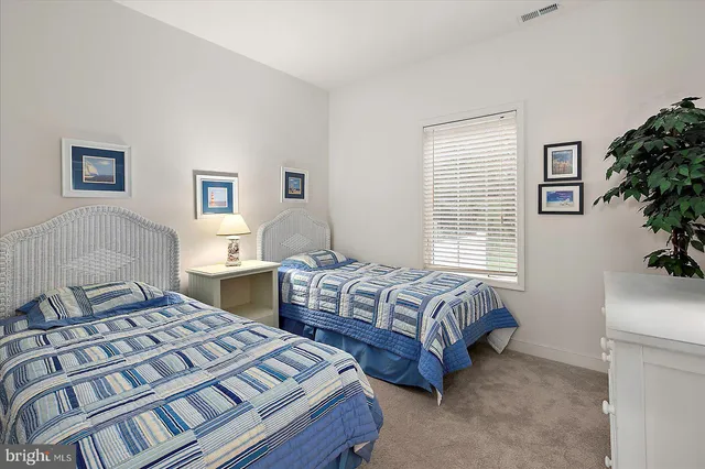 a bedroom with two beds and a potted plant