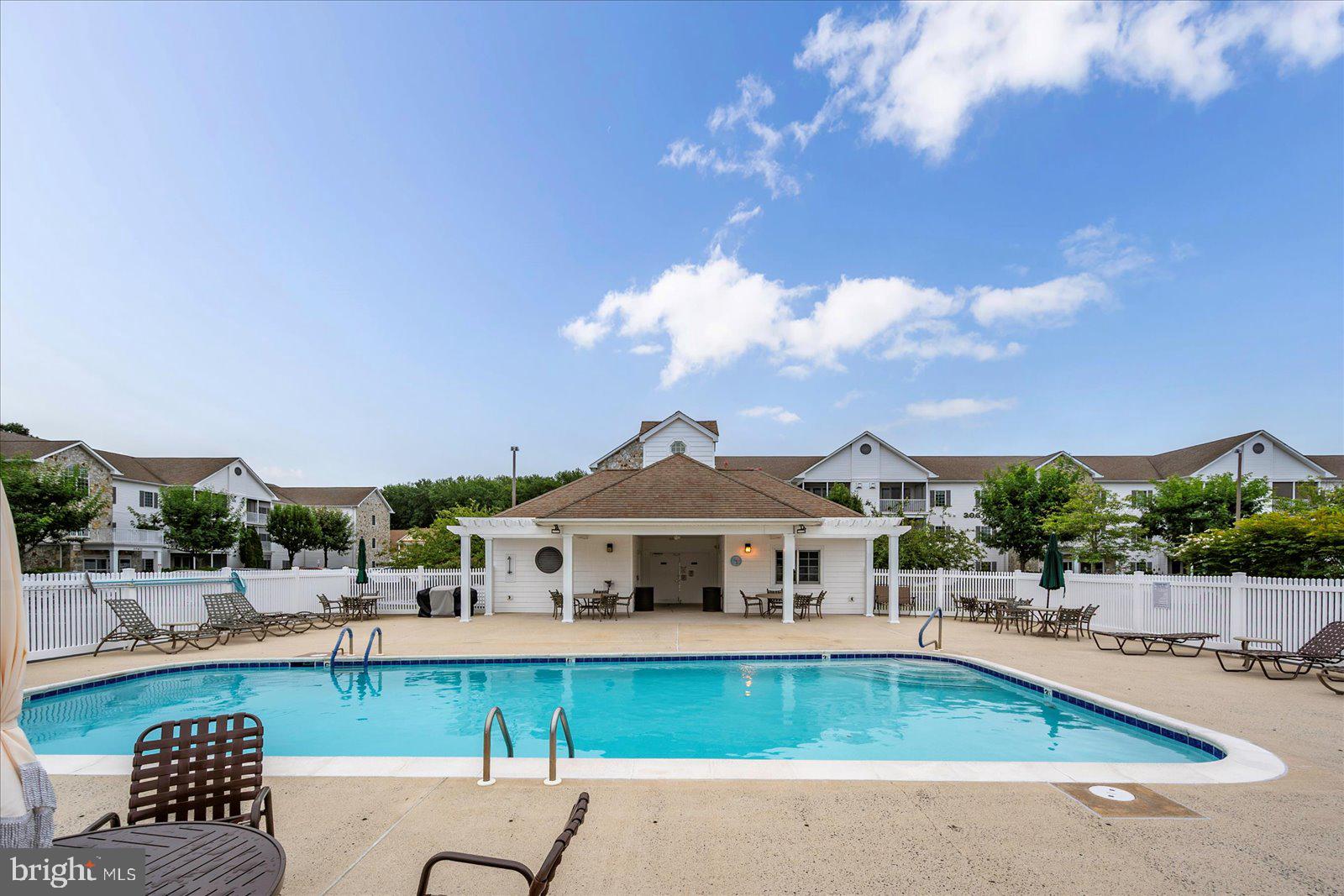 30611 Cedar Neck Road, Unit 2107 Ocean View, DE 19970 - Photo 39 of 44 a front view of a house with swimming pool having outdoor seating