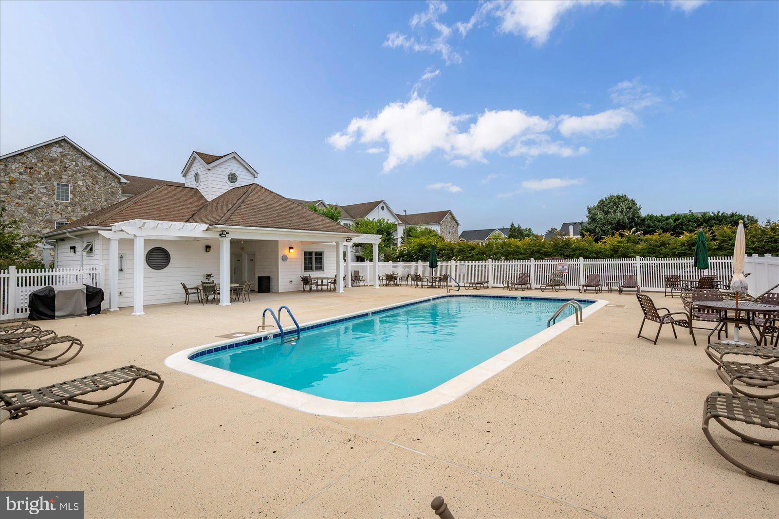 30611 Cedar Neck Road, Unit 2107 Ocean View, DE 19970 - Photo 41 of 44 a view of a house with swimming pool and sitting area