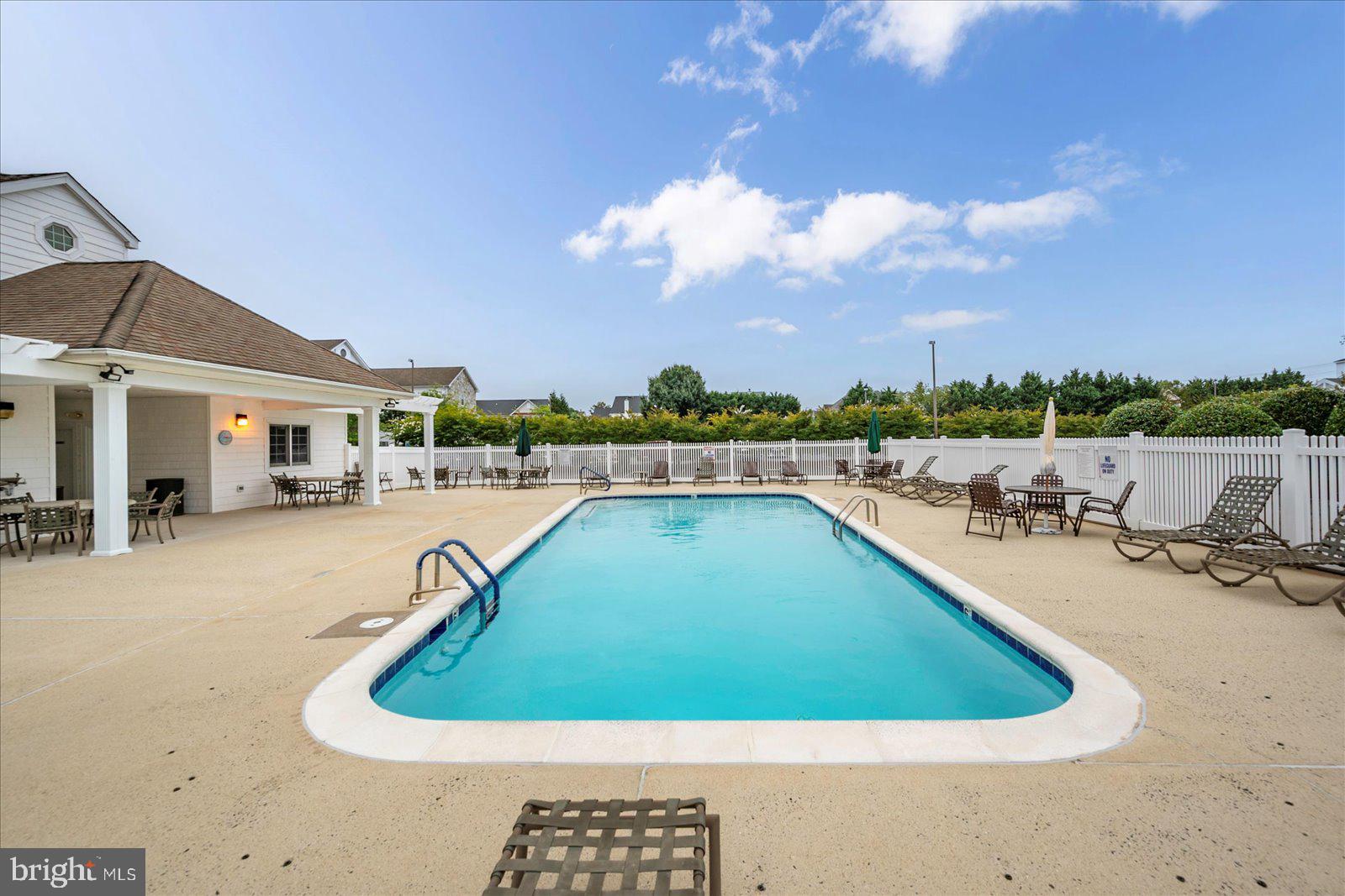 30611 Cedar Neck Road, Unit 2107 Ocean View, DE 19970 - Photo 42 of 44 a view of a swimming pool with lounge chair