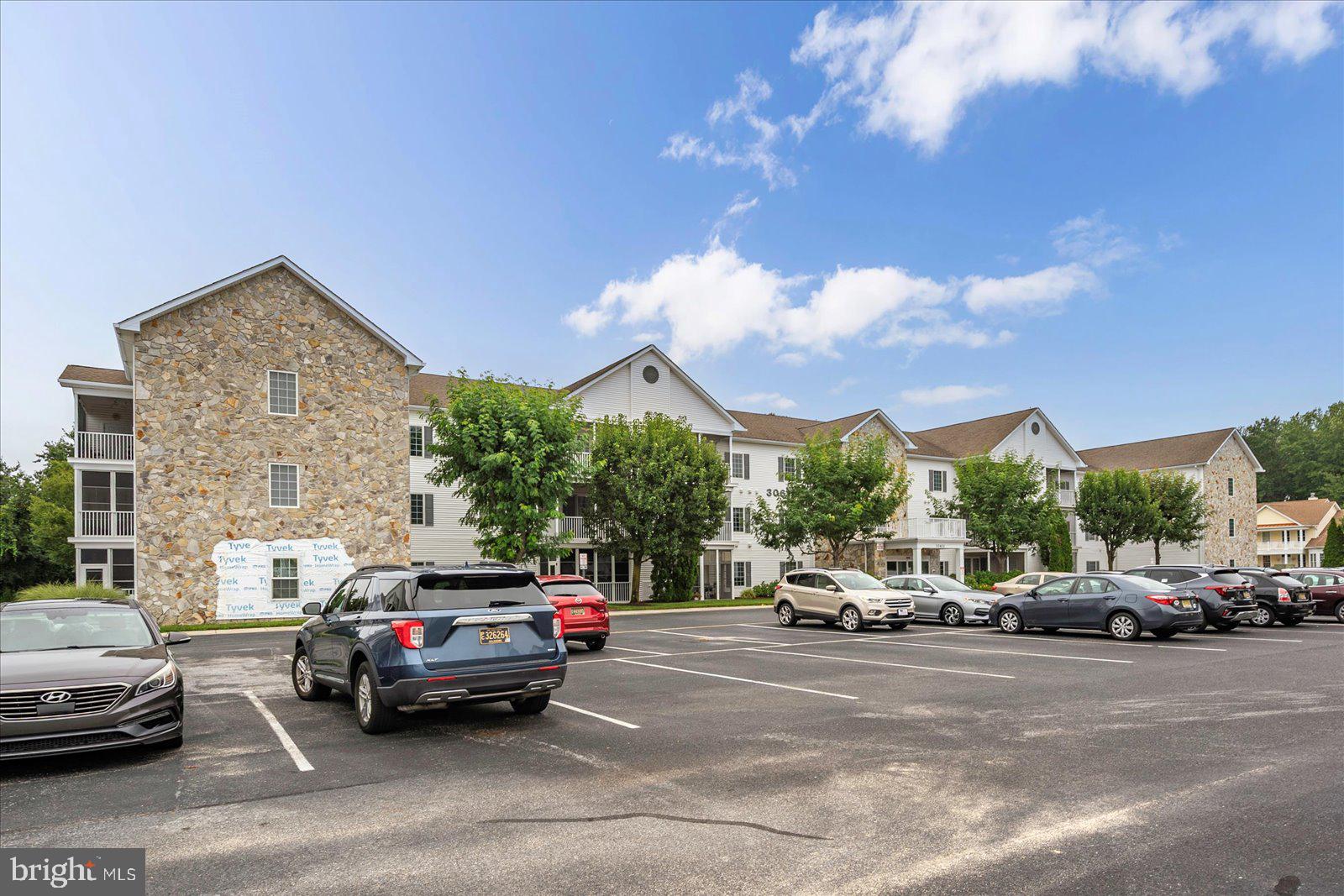 30611 Cedar Neck Road, Unit 2107 Ocean View, DE 19970 - Photo 43 of 44 a view of cars parked in front of a building