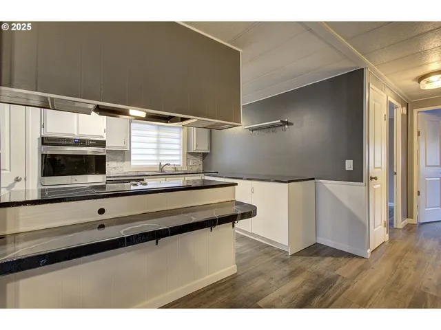 a kitchen with kitchen island sink and refrigerator