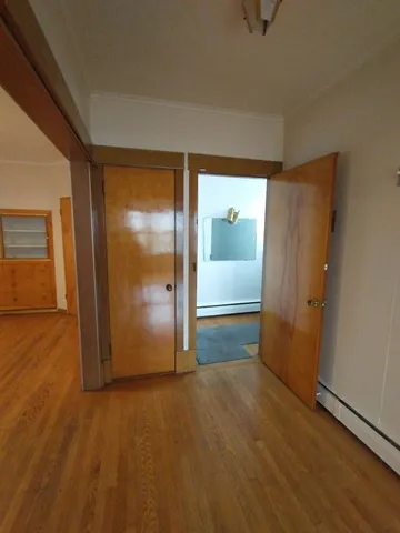 an empty room with wooden floor and door