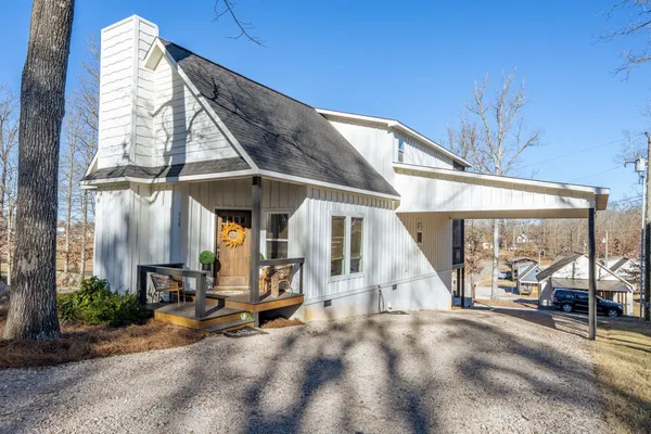 a view of a house with large windows and plants