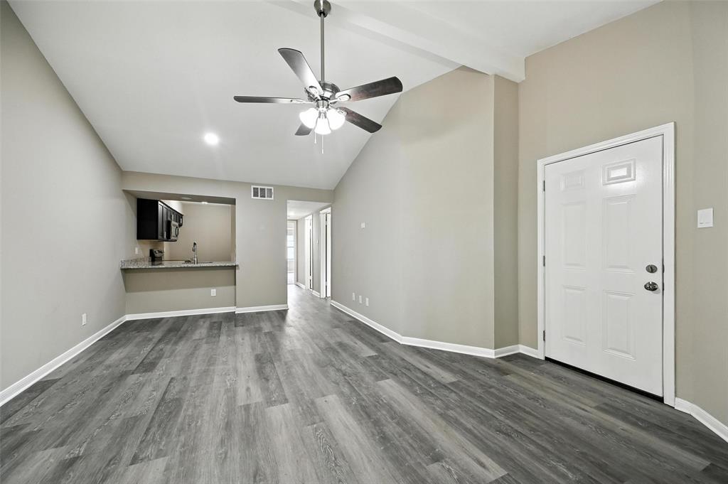 8545 Midpark Road, Unit 66 Dallas, TX 75240 - Photo 4 of 27 a view of an empty room with a window and wooden floor