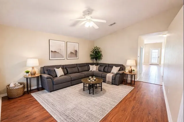 a living room with furniture and a wooden floor