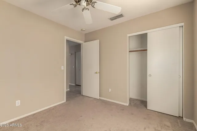 a view of an empty room with a chandelier fan