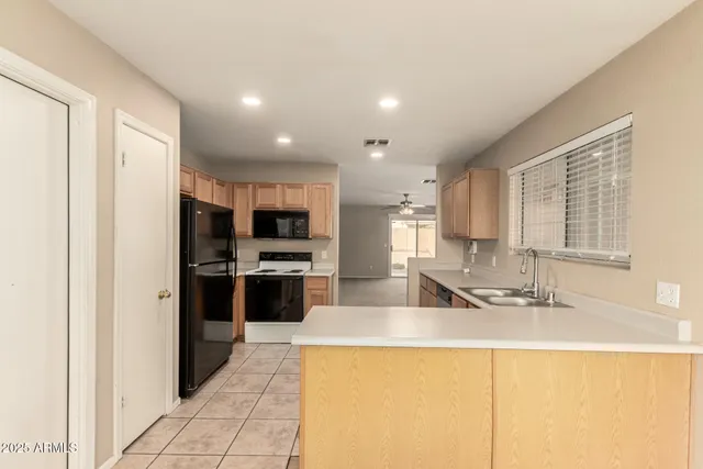 a kitchen with stainless steel appliances kitchen island sink refrigerator and stove