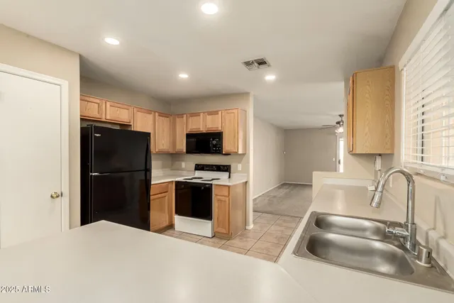 a kitchen with granite countertop a refrigerator and a sink