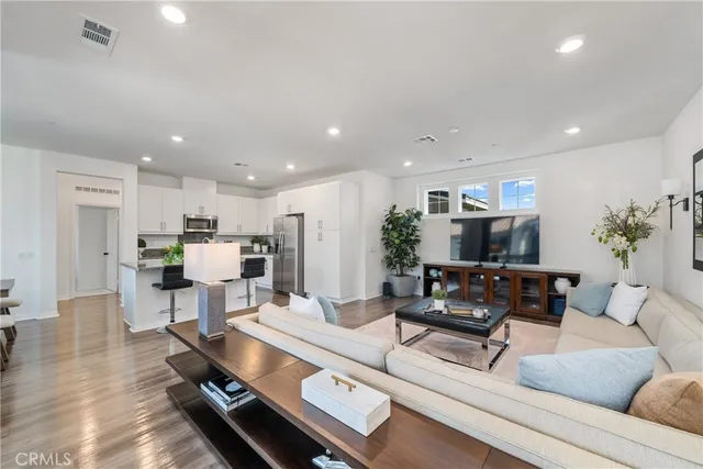 a living room with furniture a flat screen tv and a potted plant