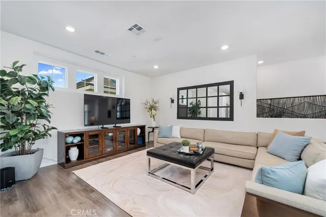 a living room with furniture and view of kitchen