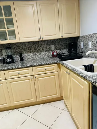 a kitchen with granite countertop white cabinets and sink