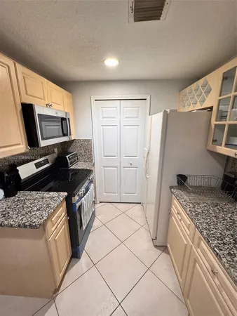 a kitchen with a stove a microwave and refrigerator