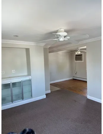 en empty room with windows and fan