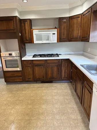 a kitchen with stainless steel appliances granite countertop a stove a sink and a microwave