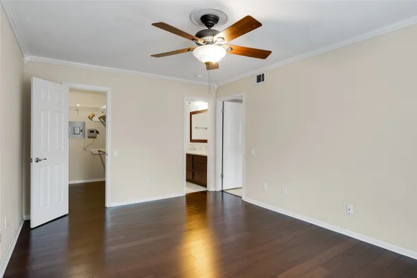 an empty room with wooden floor and ceiling fan