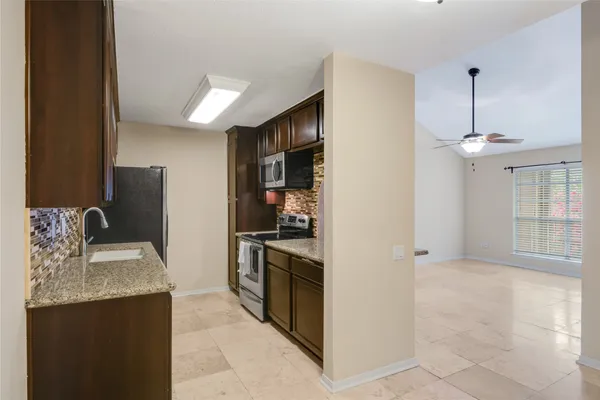 a kitchen with stainless steel appliances granite countertop a refrigerator and a sink