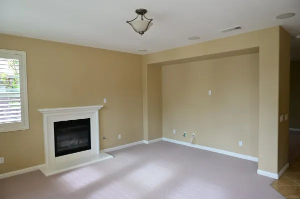 a view of an empty room with a fireplace and a window
