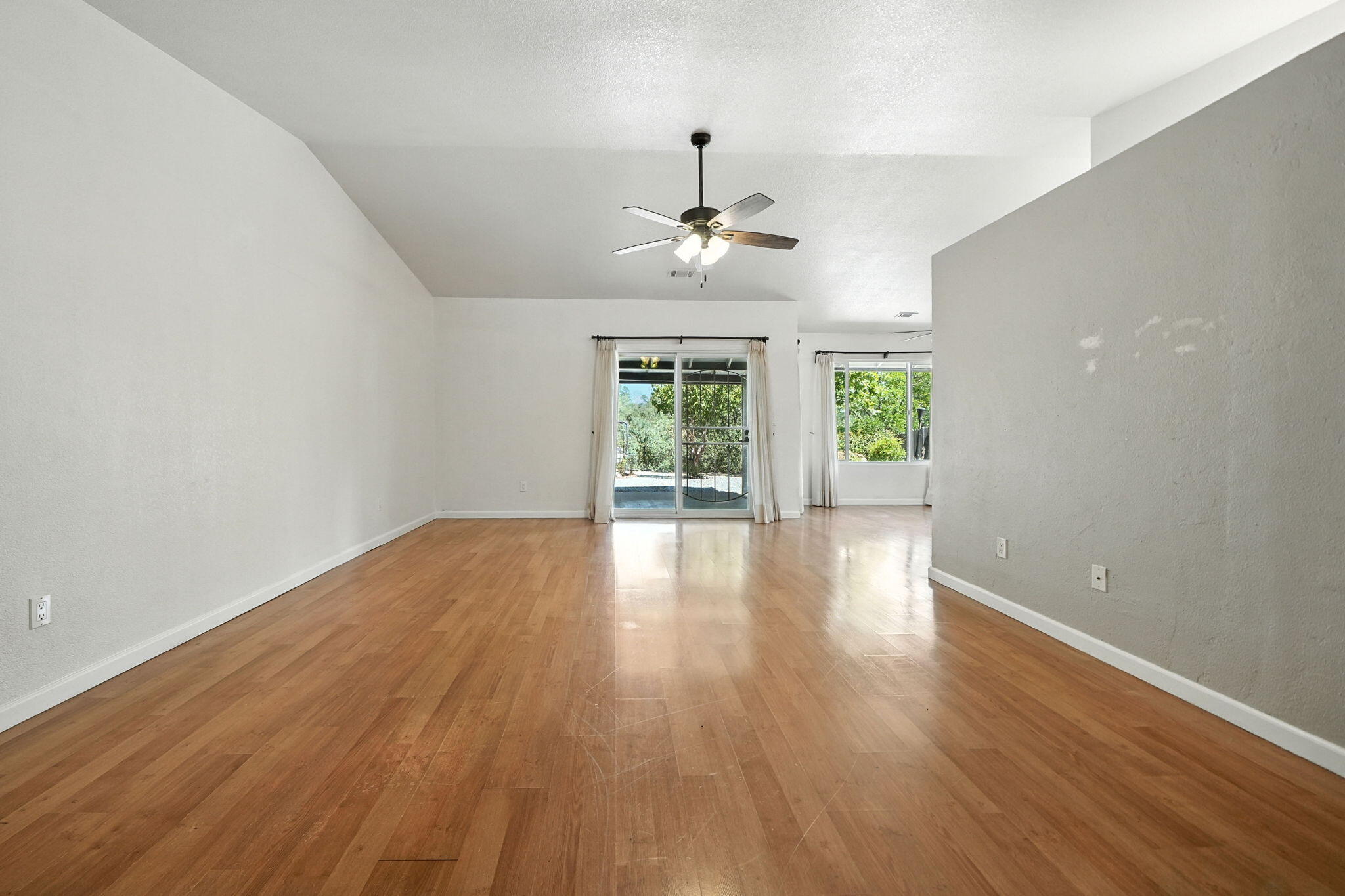 3588 Magnums Way Redding, CA 96003 - Photo 4 of 35 an empty room with wooden floor and windows