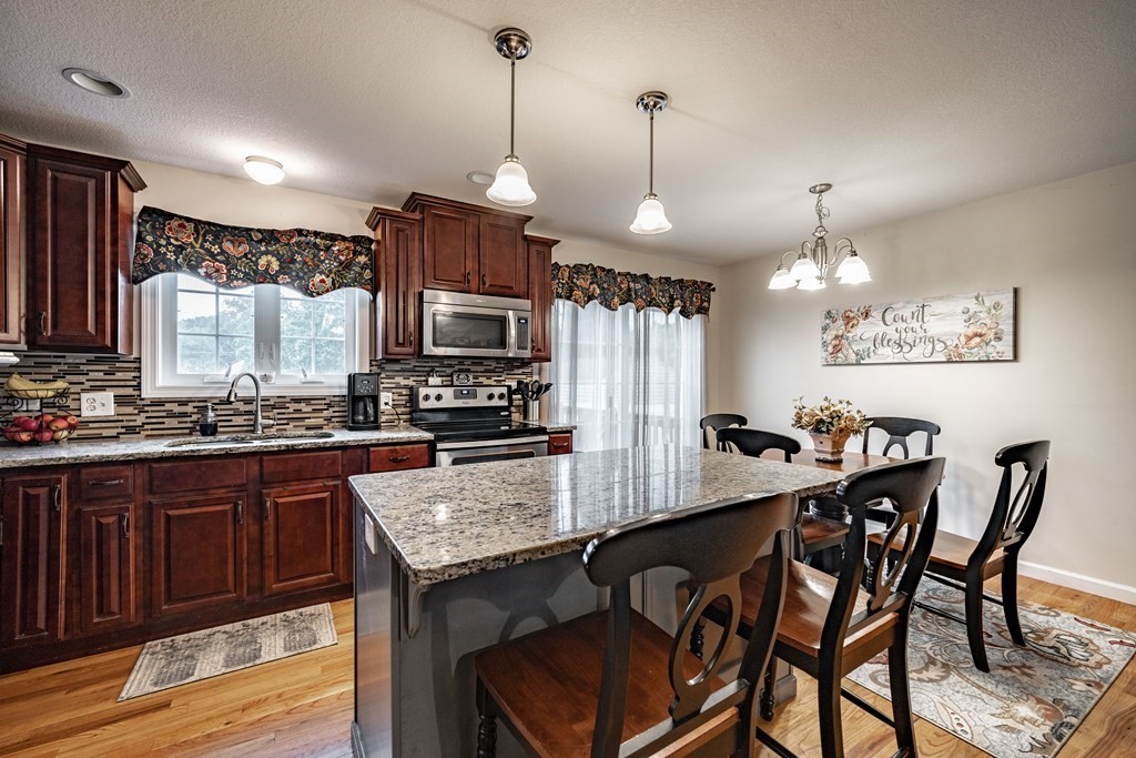 79 Judson Street Springfield, MA 01104 - Photo 12 of 38 a kitchen with granite countertop a table chairs stainless steel appliances and cabinets