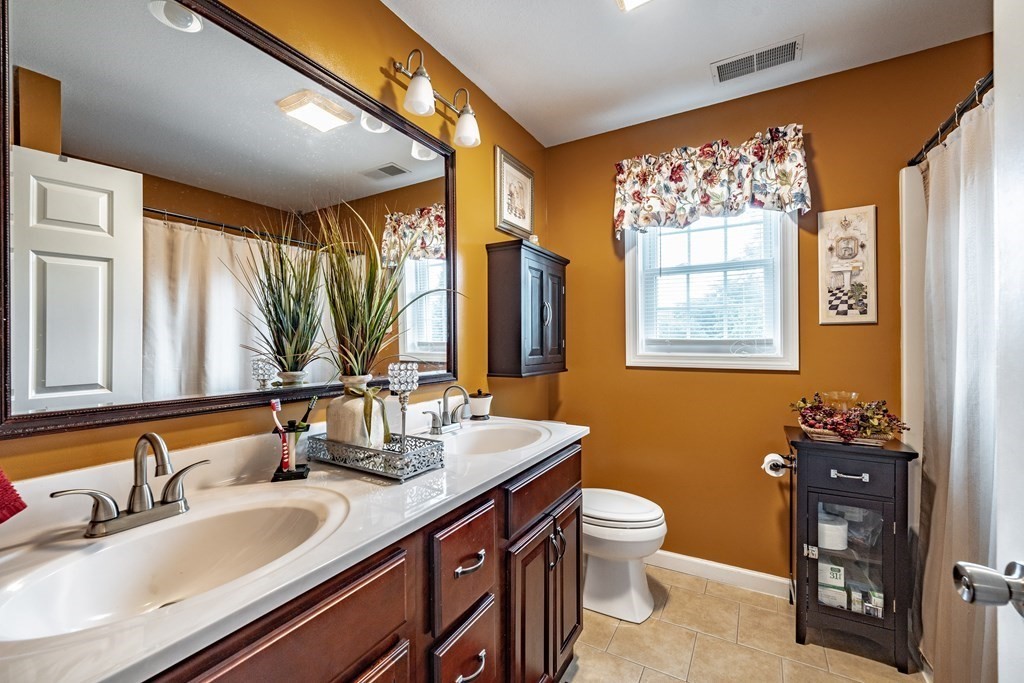 79 Judson Street Springfield, MA 01104 - Photo 34 of 38 a bathroom with a double vanity sink toilet and a mirror