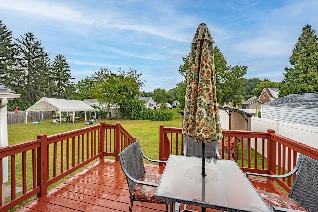 79 Judson Street Springfield, MA 01104 - Photo 35 of 38 a view of a roof deck with table and chairs a barbeque with wooden floor and fence