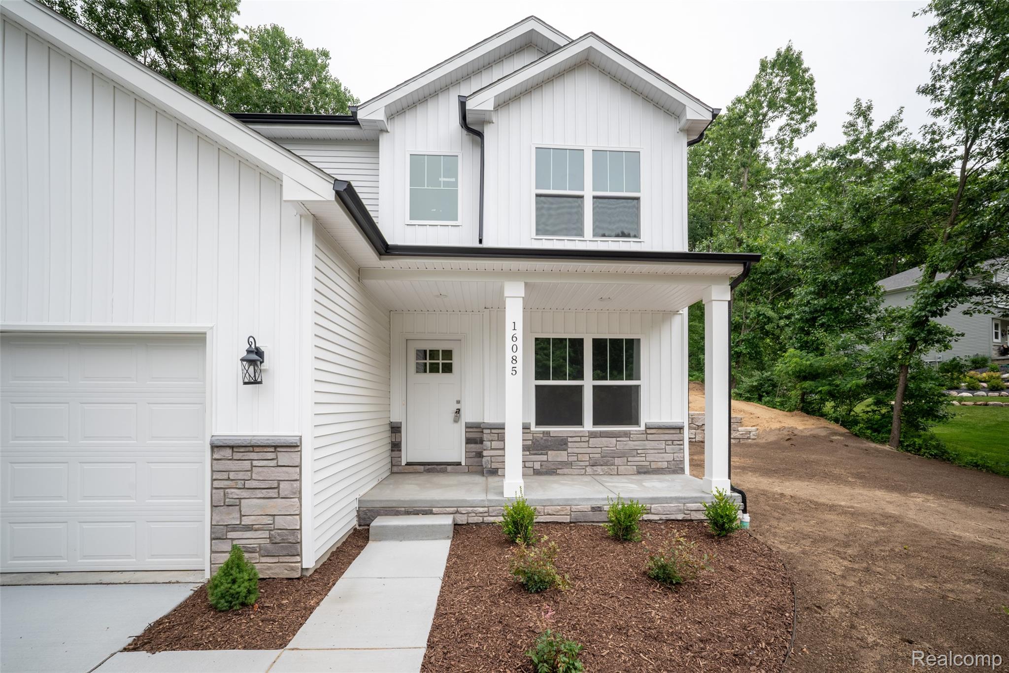 16085 Catalpa Ridge Holly, MI 48442 - Photo 27 of 40 Modern farmhouse exterior featuring white board and batten siding, horizontal siding, and a stone facade accent