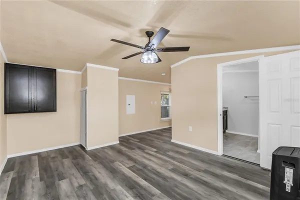 a view of an empty room with window and wooden floor