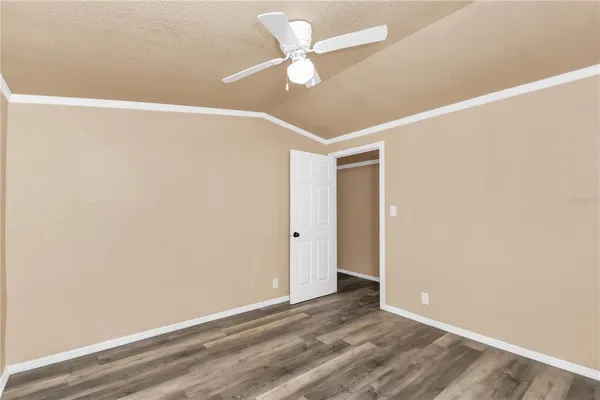 an empty room with a ceiling fan and a window