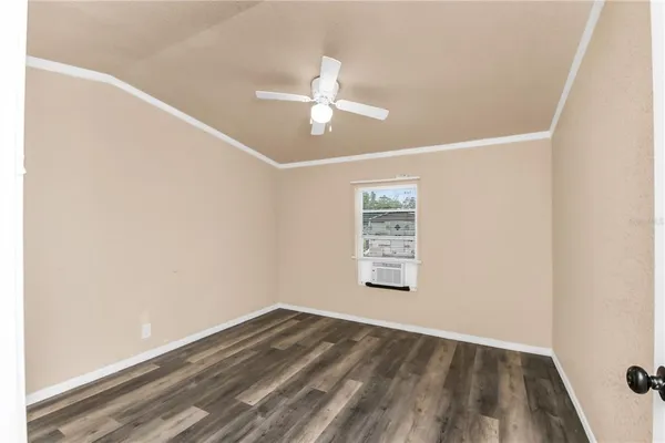 an empty room with a window and ceiling fan