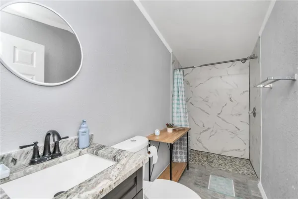 a bathroom with a sink toilet and a mirror