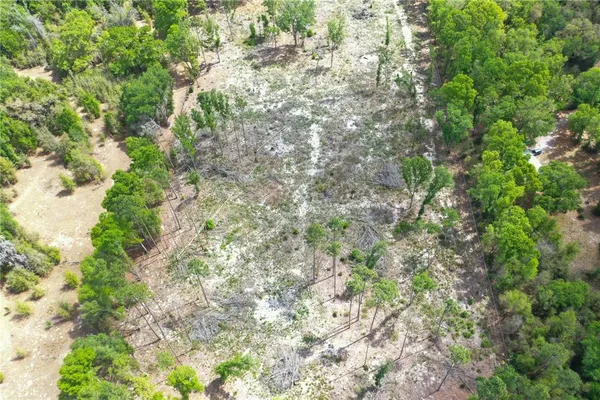 an aerial view of ocean with green space