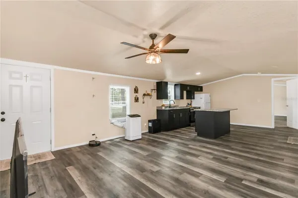 a kitchen with a stove a refrigerator and a sink with wooden floor