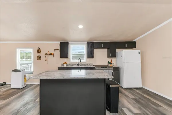 a kitchen with a sink a stove a refrigerator and white cabinets
