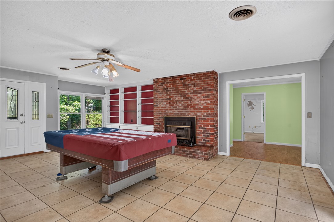 123 Robin Road Westminster, SC 29693 - Photo 12 of 50 A spacious room features a brick fireplace, built-in shelving, and large windows inviting in abundant natural light.