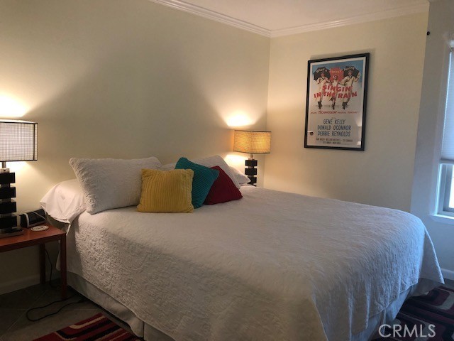 711 Pacific Coast Highway, Unit 303 Huntington Beach, CA 92648 - Photo 17 of 22 a bedroom with a bed and lamp