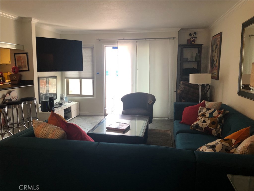 711 Pacific Coast Highway, Unit 303 Huntington Beach, CA 92648 - Photo 6 of 22 a living room with furniture and a flat screen tv
