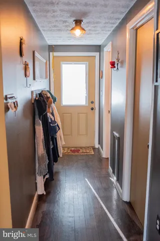 a view of a hallway with wooden floor and stairs
