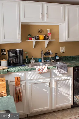 a kitchen with kitchen island granite countertop a stove and white cabinets
