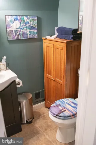 a white toilet sitting next to a wooden cabinet
