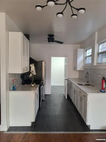 a kitchen with a sink stainless steel appliances a counter space and cabinets