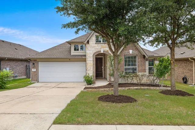 a front view of a house with a yard and garage
