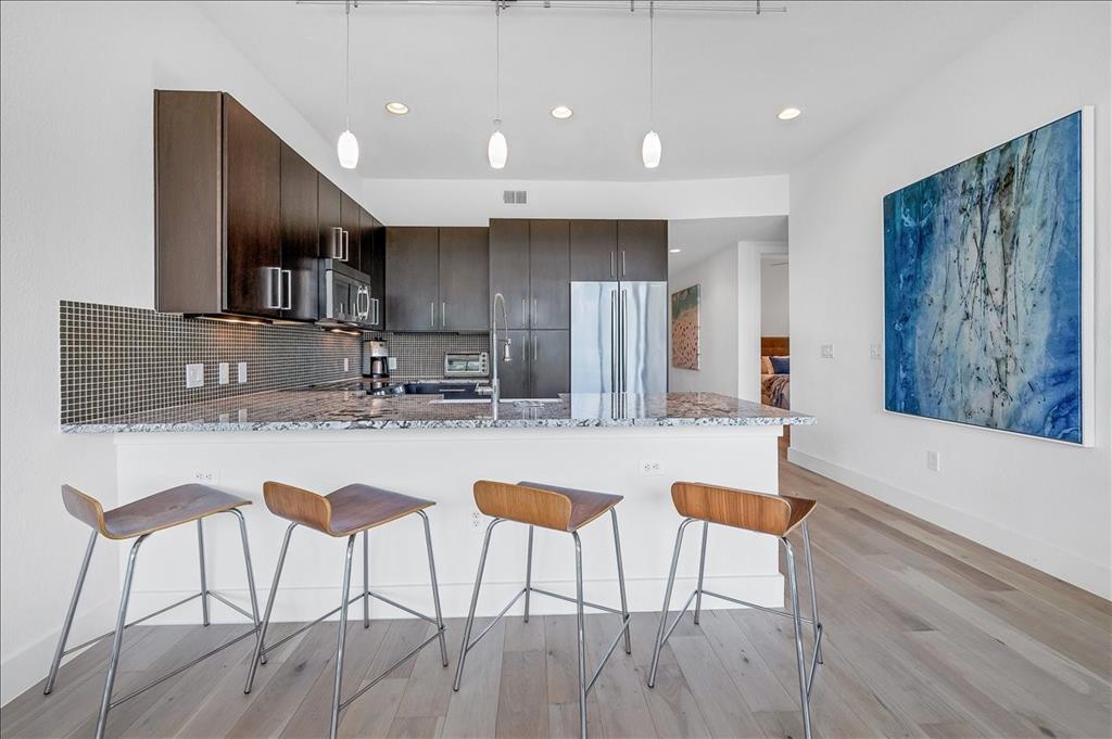 1101 Ivean Pearson Road, Unit A102 Lago Vista, TX 78645 - Photo 6 of 31 Kitchen featuring a kitchen bar, a peninsula, appliances with stainless steel finishes, decorative light fixtures, and recessed lighting