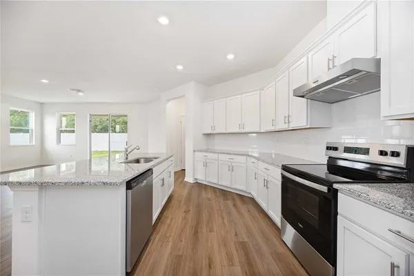 a kitchen with granite countertop cabinets stainless steel appliances a sink and a counter space