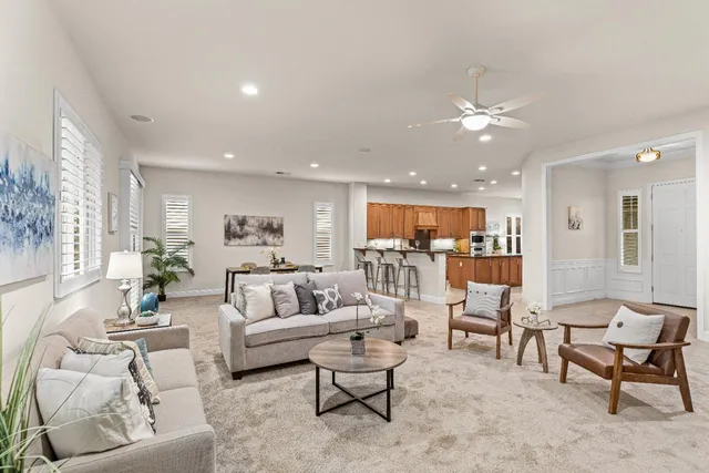 a kitchen with stainless steel appliances a sink a counter top space and living room view