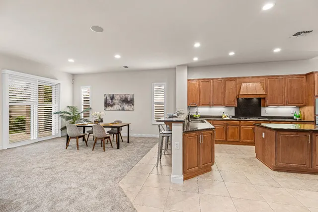 a kitchen with stainless steel appliances granite countertop a sink counter space cabinets and a large window